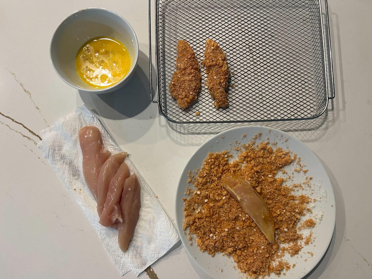 air fryer chicken fingers being dredged in coating